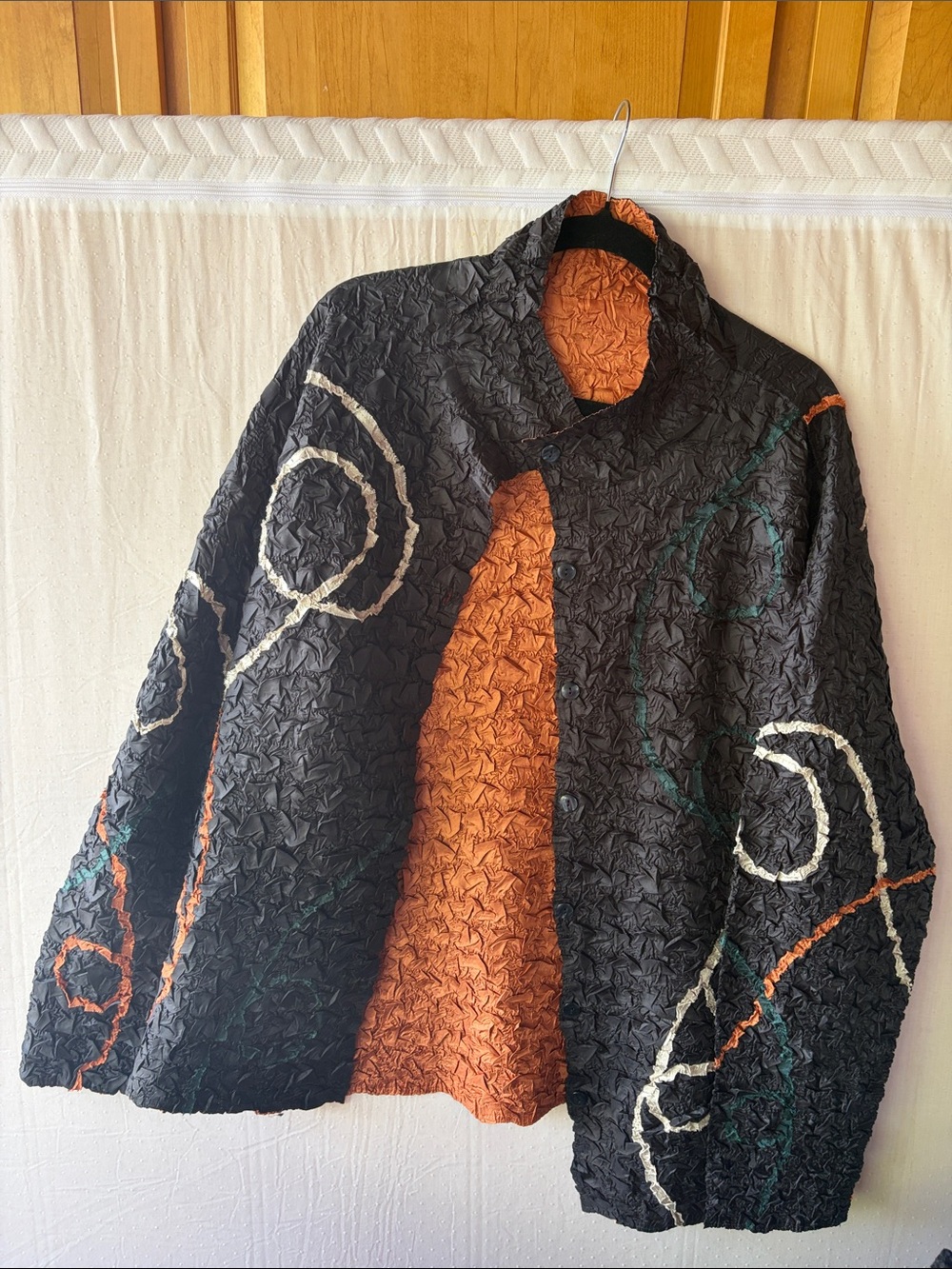 Textured Black Jacket with Orange Lining and Abstract Swirl Detail